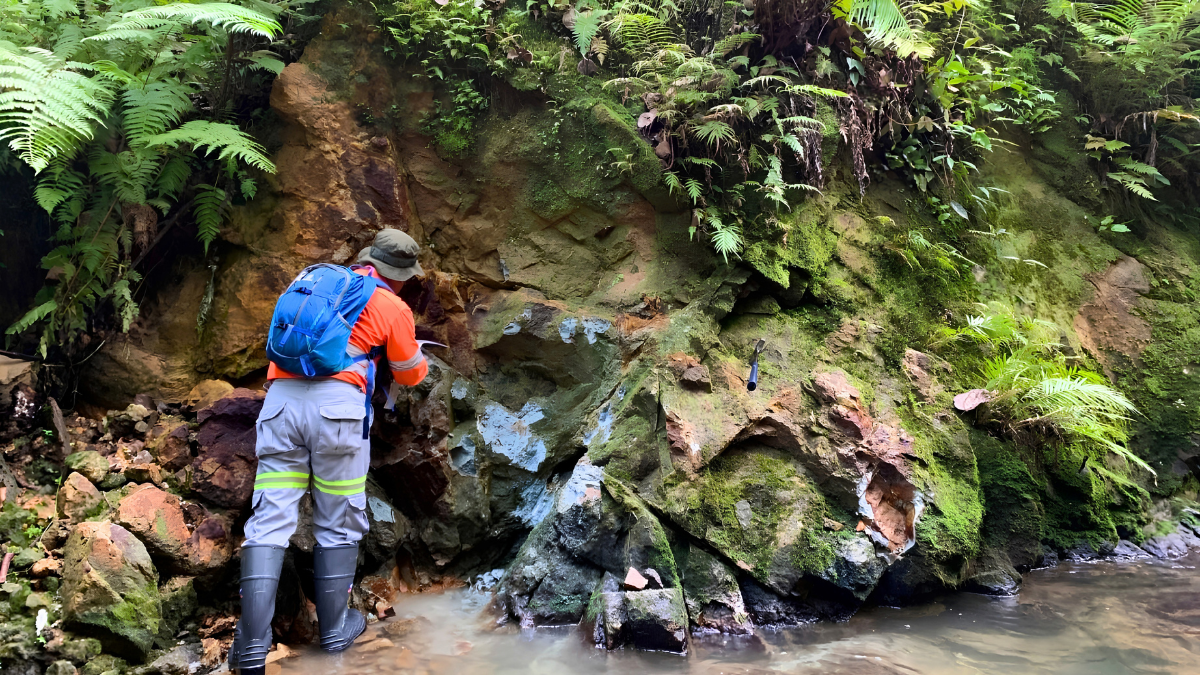 Geologists conducting exploration mining activities with geological mapping, drone surveys, and diamond core drilling at a mineral exploration site in Indonesia