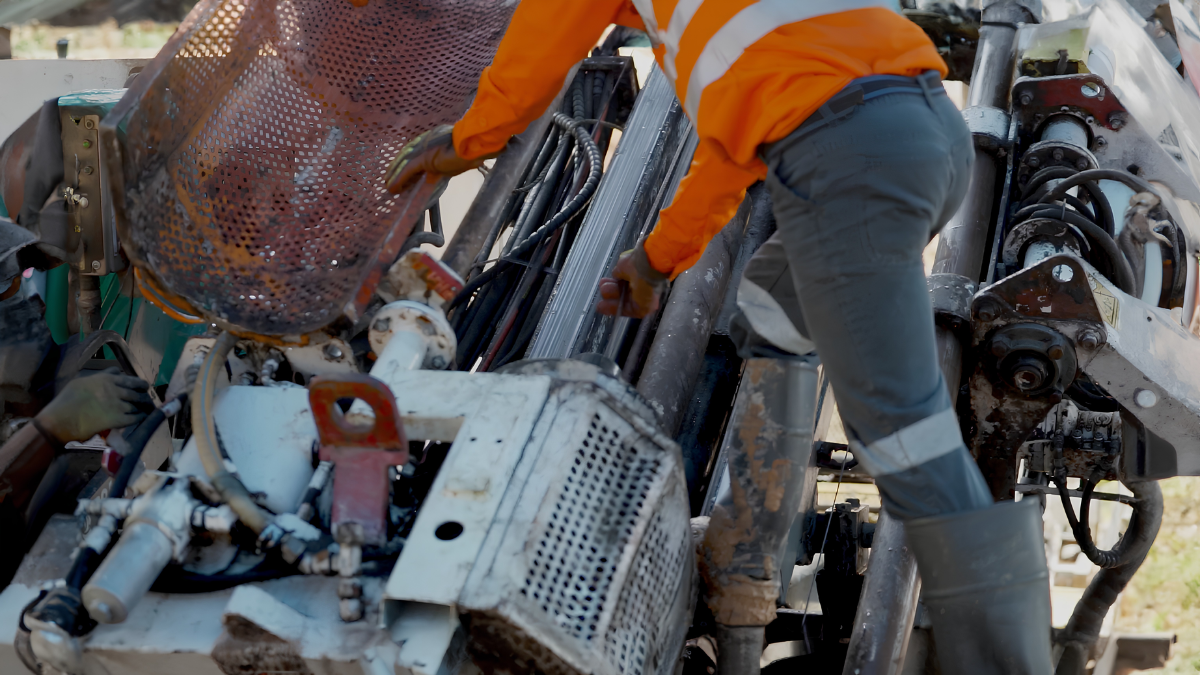 Reverse Circulation (RC) drilling rig collecting rock chip samples at a mineral exploration site in Indonesia